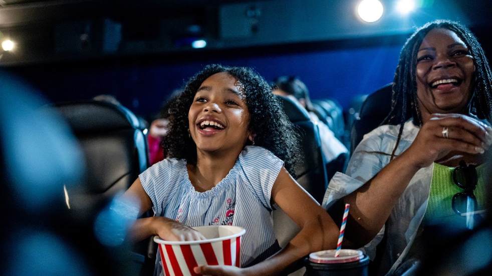 Mother and daughter smiling at the cinema